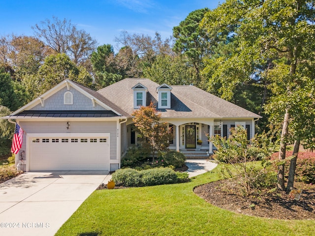 view of front of home with a front yard, a garage, and a porch