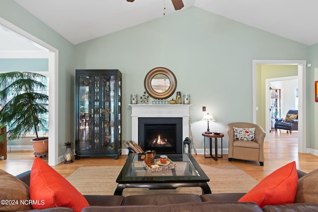 living room featuring light hardwood / wood-style flooring, lofted ceiling, ceiling fan, and plenty of natural light