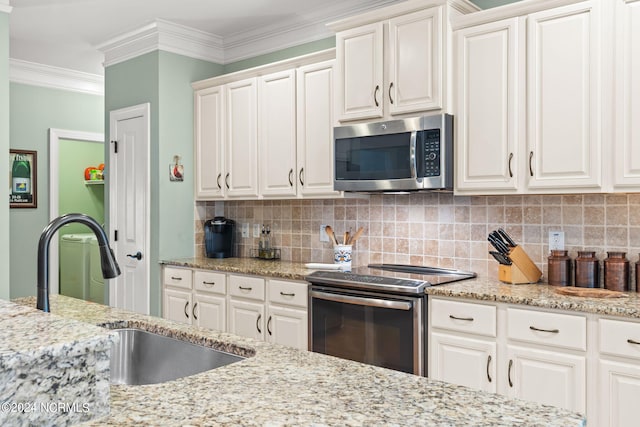 kitchen featuring ornamental molding, sink, tasteful backsplash, white cabinetry, and appliances with stainless steel finishes