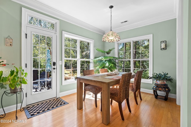 dining space featuring light wood-type flooring and crown molding