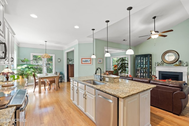 kitchen featuring dishwasher, light stone counters, sink, an island with sink, and white cabinetry