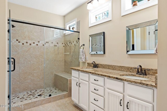 bathroom with tile patterned flooring, walk in shower, and vanity