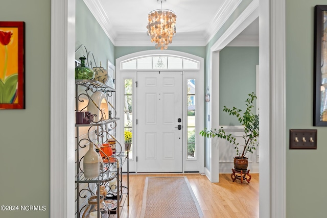 foyer entrance featuring light wood-type flooring, crown molding, and a healthy amount of sunlight