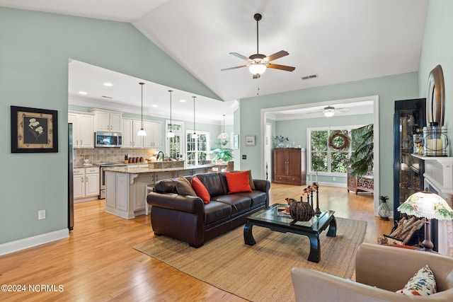 living room with high vaulted ceiling, light hardwood / wood-style floors, and ceiling fan