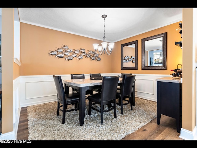 1204 Maple Ridge Rd, Wilmington, NC 28411 - dining room featuring wood finished floors, a chandelier, crown molding, wainscoting, and a decorative wall