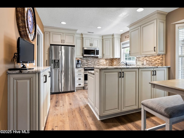 1204 Maple Ridge Rd, Wilmington, NC 28411 - kitchen with stainless steel appliances, light wood-style floors, tasteful backsplash, light stone counters, and recessed lighting