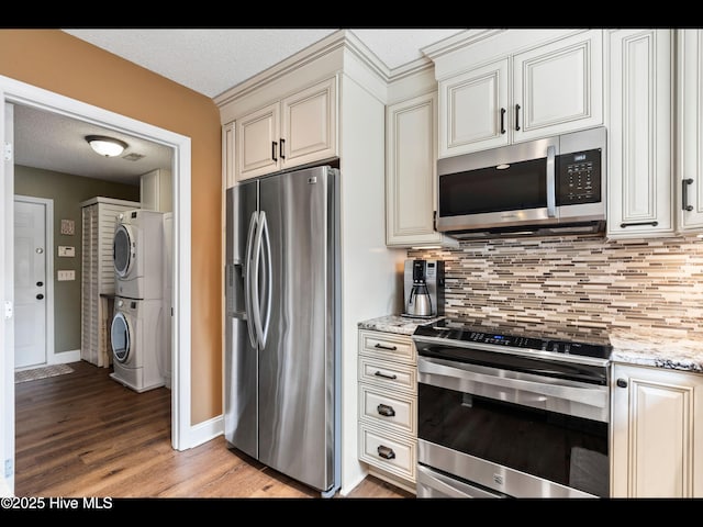 1204 Maple Ridge Rd, Wilmington, NC 28411 - kitchen with stainless steel appliances, stacked washer / dryer, light wood finished floors, decorative backsplash, and a textured ceiling