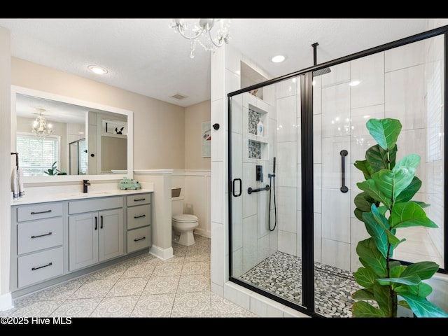 1204 Maple Ridge Rd, Wilmington, NC 28411 - bathroom featuring a chandelier, vanity, a shower stall, a decorative wall, and a wainscoted wall