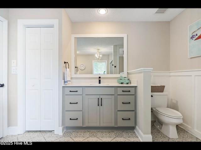 1204 Maple Ridge Rd, Wilmington, NC 28411 - bathroom featuring vanity, a closet, a chandelier, tile patterned flooring, and a wainscoted wall