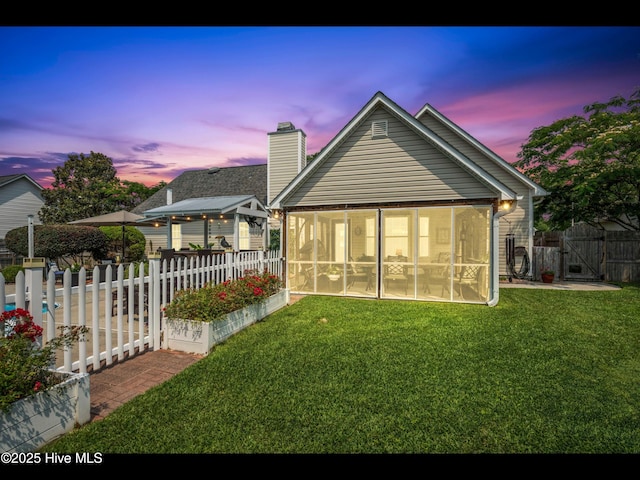 1204 Maple Ridge Rd, Wilmington, NC 28411 - rear view of house with a sunroom, a chimney, a fenced backyard, and a gate