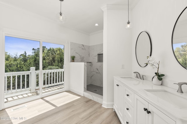 10002 Coast Guard Rd, Emerald Isle, NC 28594 - bathroom featuring plenty of natural light, a marble finish shower, wood finished floors, double vanity, and crown molding