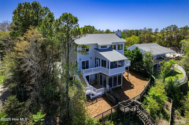 10002 Coast Guard Rd, Emerald Isle, NC 28594 - rear view of property featuring stairs, a sunroom, a chimney, and a shingled roof