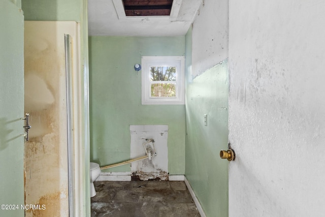 bathroom with toilet and concrete floors