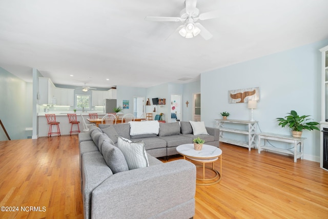 living room with ceiling fan and light hardwood / wood-style floors