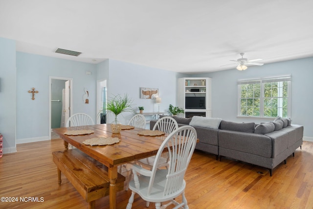 dining area with light hardwood / wood-style flooring and ceiling fan