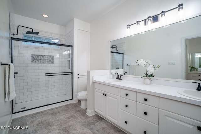 bathroom with vanity, toilet, and a shower with shower door