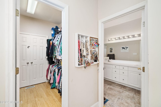 spacious closet with sink and light wood-type flooring