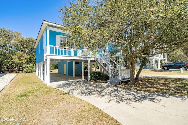 raised beach house featuring a carport and a front yard