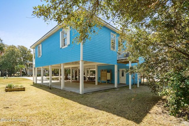 back of house featuring a lawn and a patio area