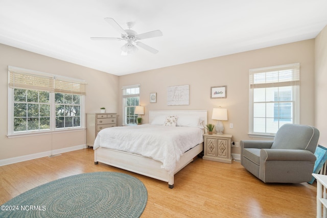 bedroom with multiple windows, light hardwood / wood-style flooring, and ceiling fan