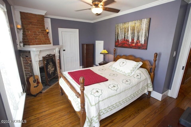 bedroom with a brick fireplace, ceiling fan, dark hardwood / wood-style flooring, and ornamental molding