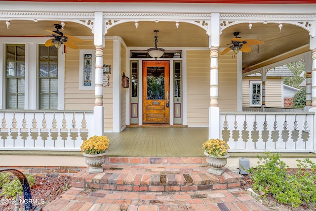 view of exterior entry featuring ceiling fan and a porch