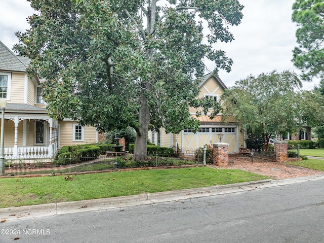 view of property hidden behind natural elements with a front yard and a garage