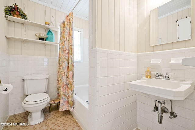 bathroom featuring tile walls, shower / tub combo, and toilet