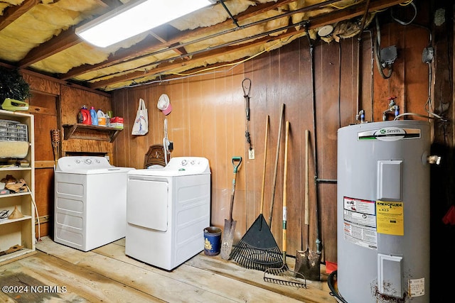 laundry room with washing machine and dryer, electric water heater, and light wood-type flooring