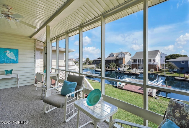 sunroom / solarium featuring ceiling fan, a water view, and a wealth of natural light