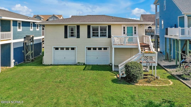 back of property with a garage and a yard