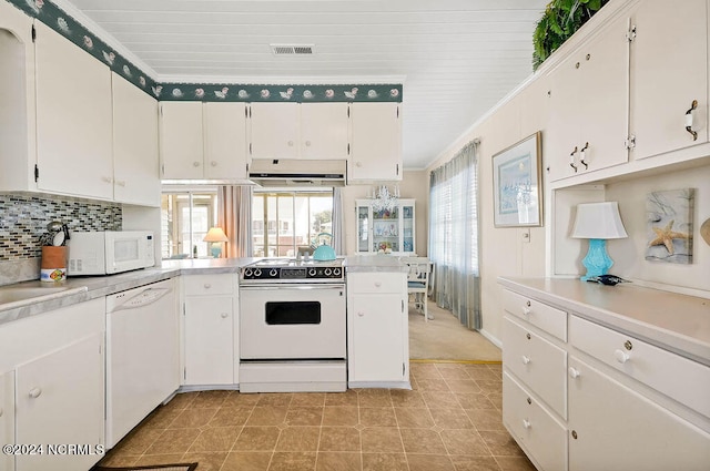 kitchen with decorative backsplash, white appliances, and white cabinetry