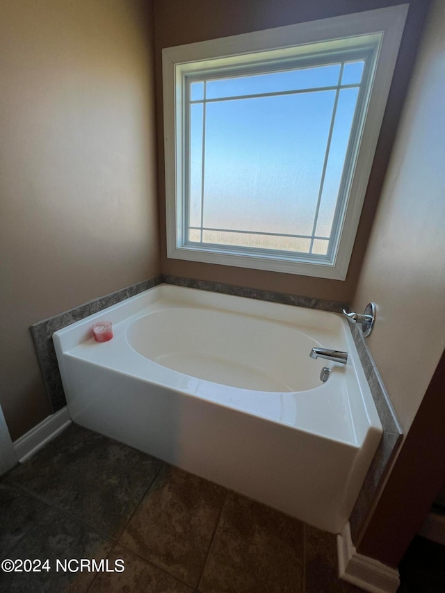 bathroom featuring a washtub, tile patterned floors, and a healthy amount of sunlight