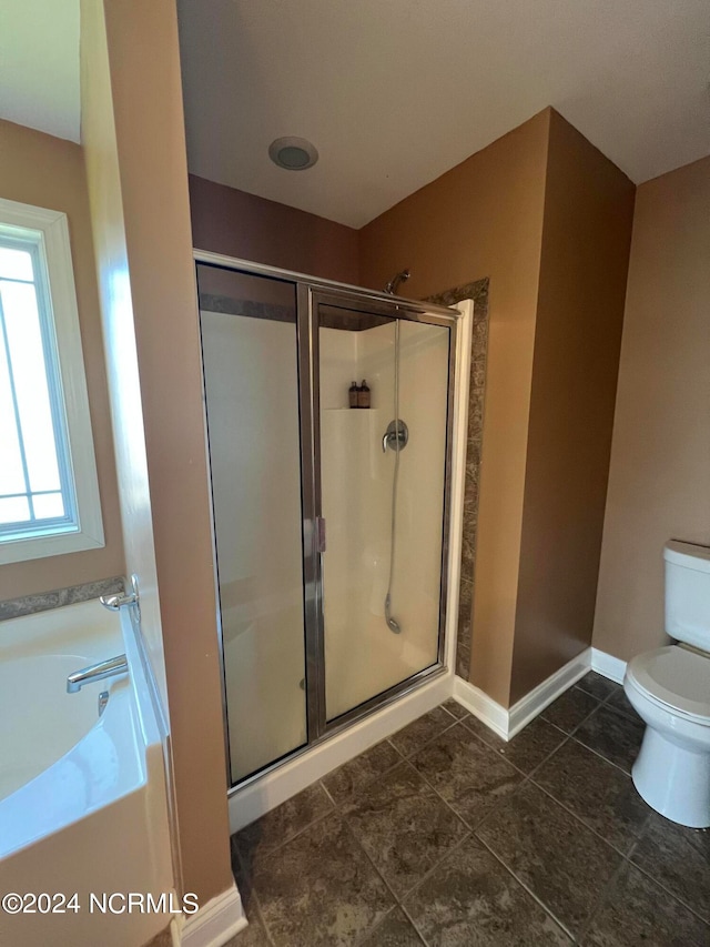 bathroom with tile patterned flooring, shower with separate bathtub, and toilet