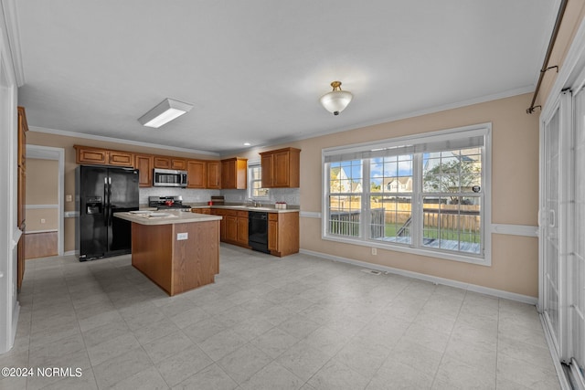 kitchen featuring sink, black appliances, a center island, crown molding, and decorative backsplash