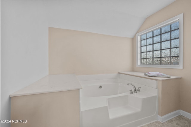 bathroom featuring lofted ceiling, a bath, and tile patterned flooring