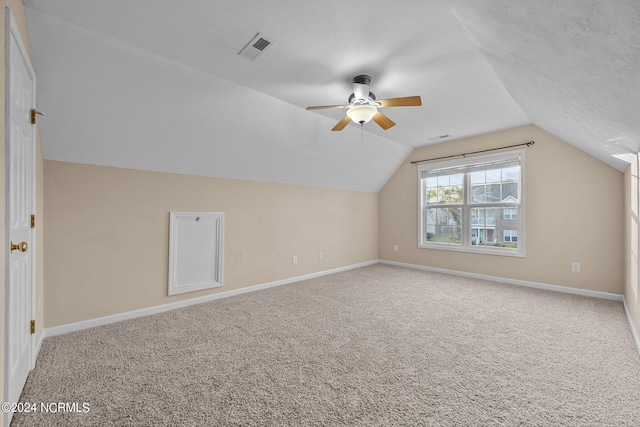 additional living space with lofted ceiling, carpet, a textured ceiling, and ceiling fan