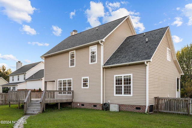 back of property with a wooden deck and a lawn