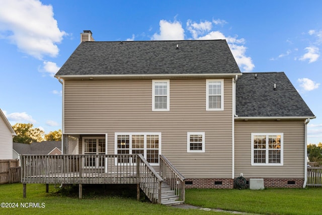 rear view of property with a wooden deck and a yard