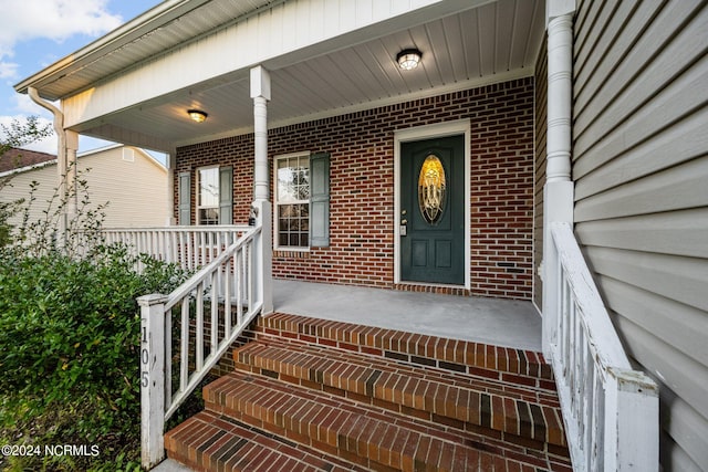 view of exterior entry featuring a porch