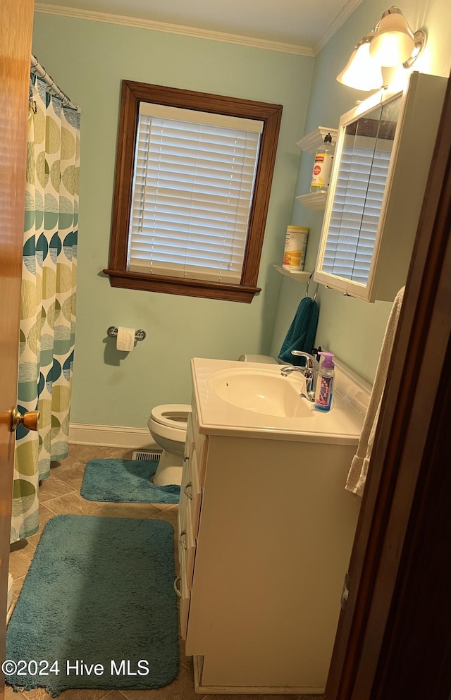 bathroom with toilet, vanity, tile patterned floors, and crown molding