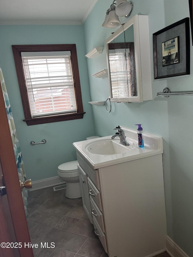 bathroom featuring tile patterned flooring, vanity, ornamental molding, and toilet