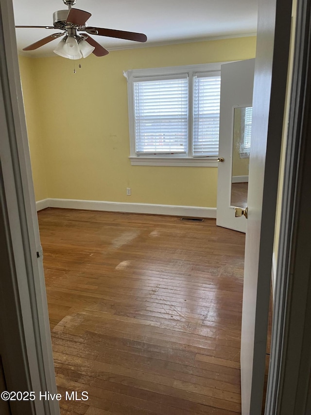 empty room with ceiling fan and hardwood / wood-style floors