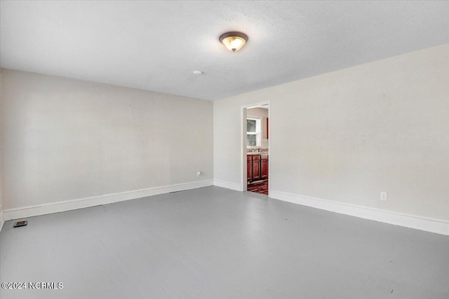 empty room with a textured ceiling and concrete floors