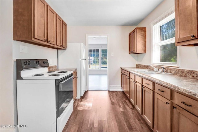 601 S Andrews Ave, Goldsboro, NC 27530 - kitchen featuring white range with electric cooktop, light countertops, brown cabinets, a sink, and dark wood finished floors