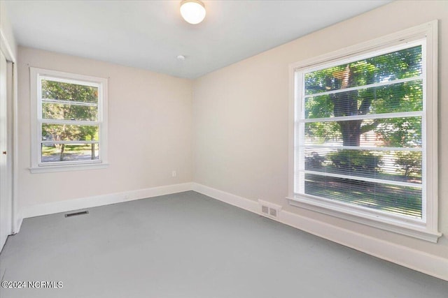 spare room featuring concrete floors and a wealth of natural light