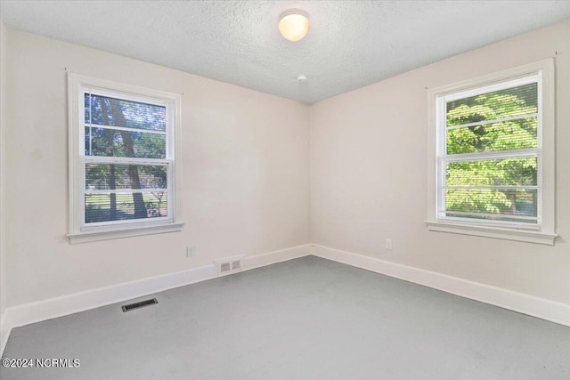 601 S Andrews Ave, Goldsboro, NC 27530 - spare room with a textured ceiling, baseboards, visible vents, and concrete flooring