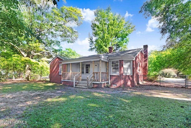 601 S Andrews Ave, Goldsboro, NC 27530 - view of front facade featuring a front yard, fence, covered porch, and a chimney