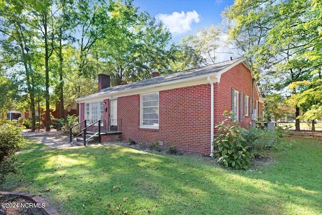 601 S Andrews Ave, Goldsboro, NC 27530 - exterior space with fence, a chimney, a yard, and brick siding