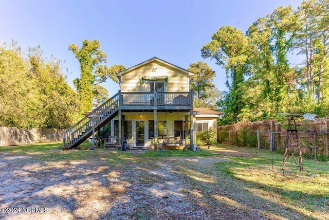 rear view of property with a yard and a deck